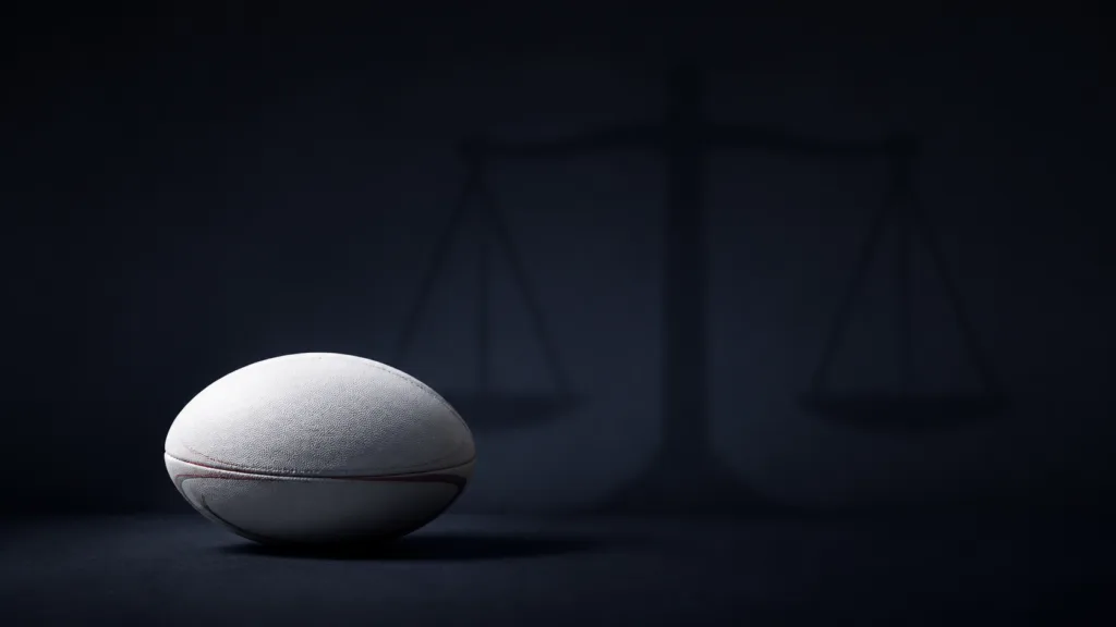 Rugby ball with subtle scales of justice representing the former players’ brain-injury court case